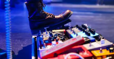 A person using a guitar pedal on a concert