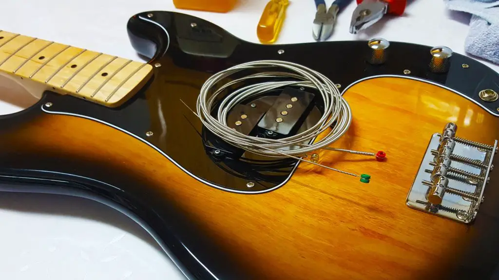 A guitar pickup and a set of strings on a guitar