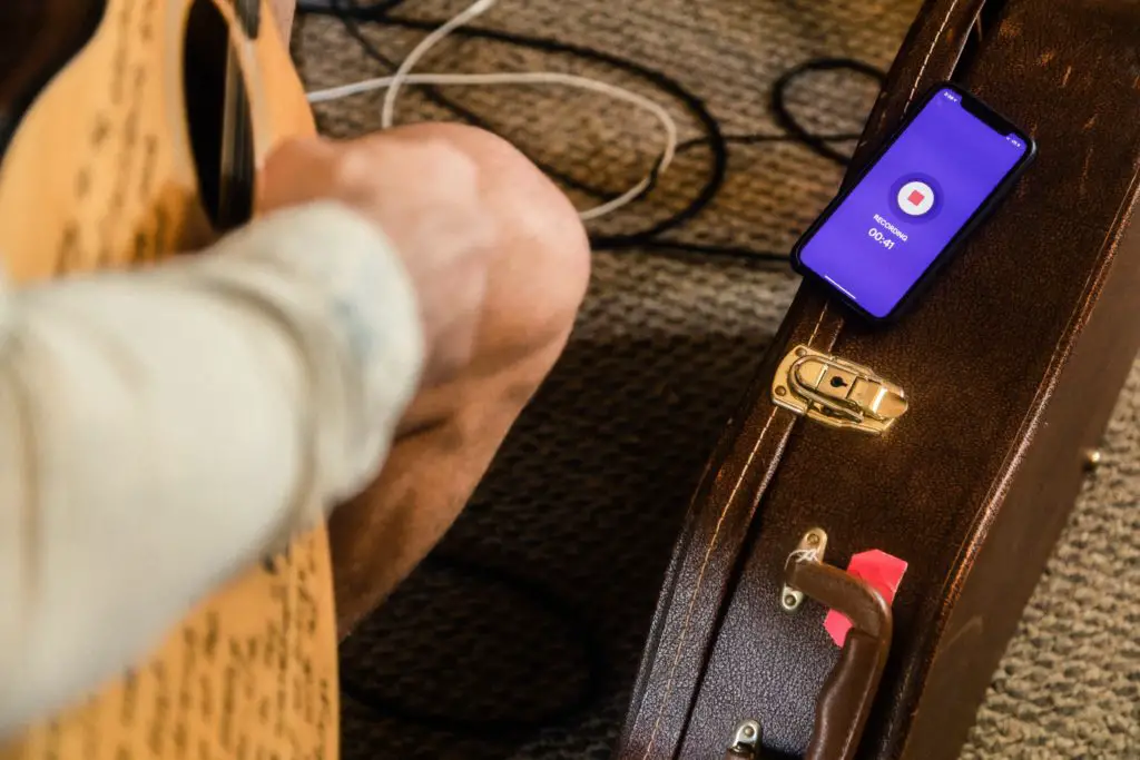 A person using a mobile app to tune his guitar
